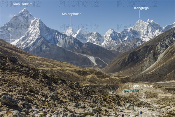 Looking back from the steep approach to Thokla on the Everest Base Camp trekking route. Dughla settlement is below, located on the way between Dingboche or Pheriche and Lobuche. It is Ama Dablam on the left-hand side, Kangtega on the right, and among other over 6000 m high peaks, Malanphulan draws the attention with its attractive, unclimbed north face. Photo with peak labels. Khumbu, the Everest Region, Himalayas. Sagarmatha National Park, a UNESCO World Heritage Site. Solukhumbu, Nepal, Asia
