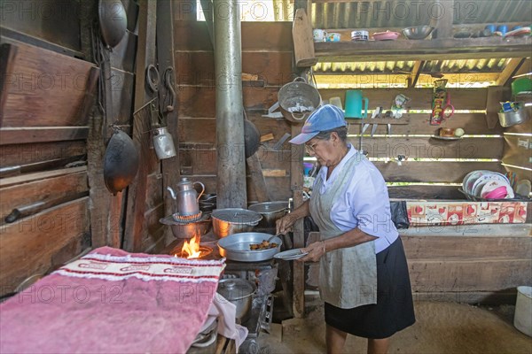 Muelle San Carlos, Costa Rica, A woman cooks over a wood-burning store in a rural farmhouse, Central America