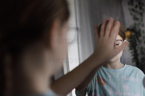 Ten year old girl betrays herself in the mirror, Bonn, Germany, Europe