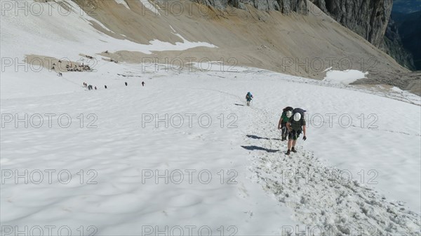 View of the glacier in the alps and tourists marching on it. Zugspitze massif in the bavarian alps, Dolomites, Italy, Europe