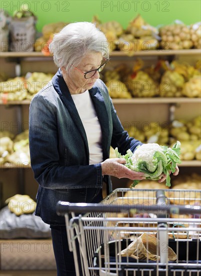 Older woman buys a cauliflower in the supermarket, Radevormwald, Germany, Europe