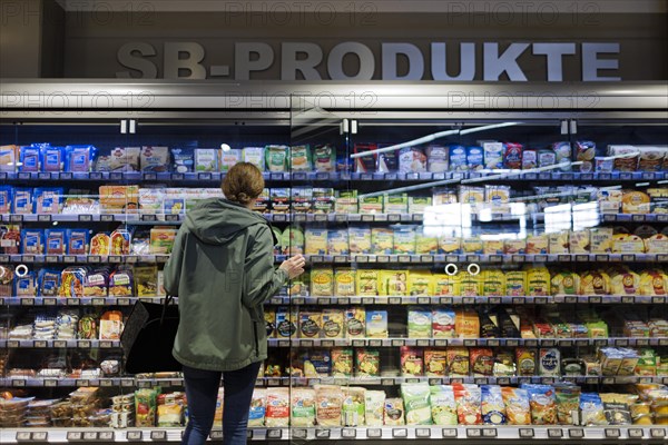 Young woman shopping in supermarket. Radevormwald, Germany, Europe