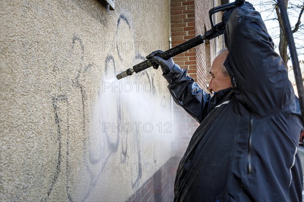 Removal of graffiti from house wall, high-pressure cleaner, residential area, Duesseldorf, North Rhine-Westphalia, Germany, Europe