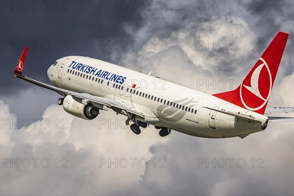 Turkish Airlines Boeing 737-800 aircraft on take-off and climb, dark thunderclouds, Stuttgart, Baden-Wuerttemberg, Germany, Europe