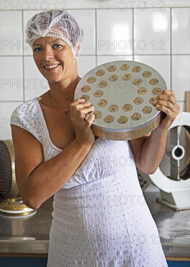 Woman with hair protection and a noodle mould, Finkensteiner Nudelfabrik, Finkenstein am Faaker See, Villach region, Carinthia, Austria, Europe