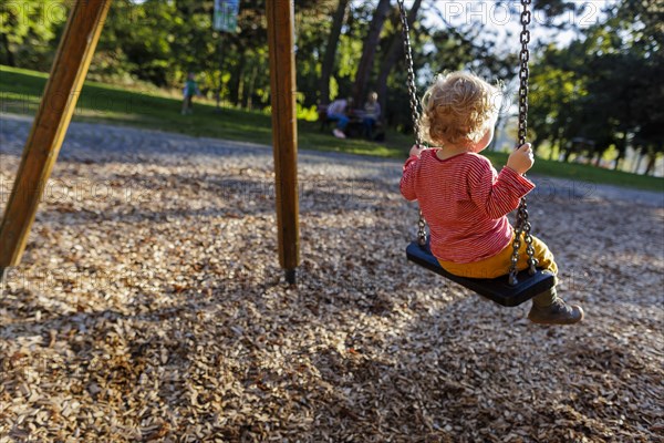 Child on a swing. Bonn, Germany, Europe