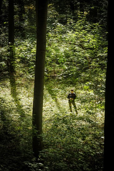 An employee of the Northwest German Forest Research Institute checks the stand of deciduous trees on an experimental plot in a deciduous forest in Lower Saxony. Here, research is being conducted into how the forest can be prepared for the challenges in times of climate change. Mackenrode, 28.06.2022, Mackenrode, Germany, Europe