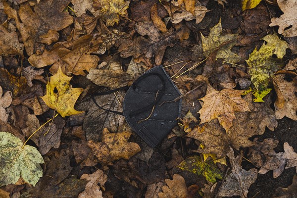 An FFP2 mask lying in the foliage, taken in Grunewald in Berlin, 16.11.2022., Berlin, Germany, Europe