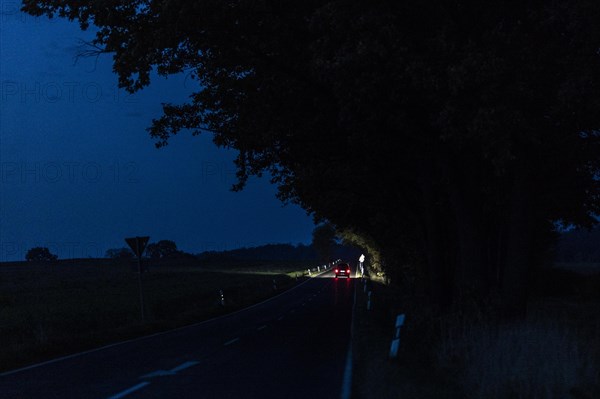 A car driving along a country road at blue hour in Reichenbach, Reichenbach, Germany, Europe
