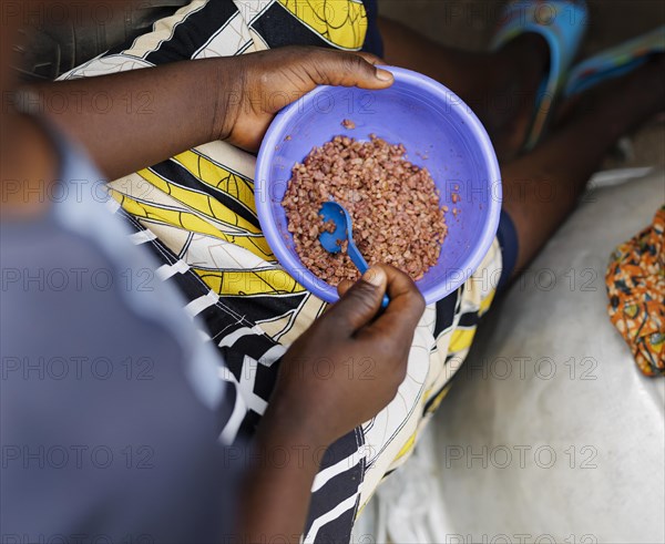 Woman is rice from a plastic bowl in Ghana, Accra, 21.02.2023., Accra, Ghana, Africa