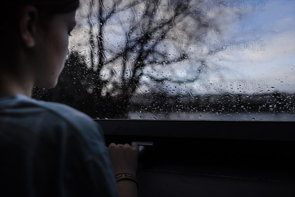 Girl looking out of the window, Bonn, Germany, Europe