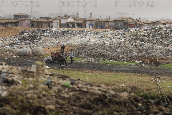 Textile dump in Accra, 21.02.2023. Wild rubbish dump of textile waste where several thousand people live, Accra, Ghana, Africa