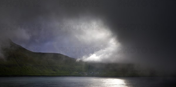 The island of Kalsoy with the small village of Mikladalur in the North Atlantic with very dramatic lighting, Faroe Islands, Foroyar, Denmark, Europe