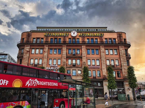 Bus stop, red double-decker bus in front of the house of the Swedish tabloid Aftonbladet, evening sky, Stockholm, Sweden, Europe