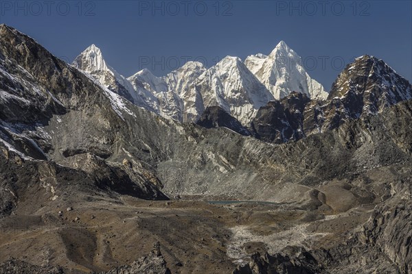 View towards the West from Chukhung Ri, a trekking peak in the Imja Khola valley. Kongma La is in the view, the lowest point on the ridge above the visible lake. Left of it, the ridge rises towards Pokalde, another peak available to trekkers. Behind the pass, in far-distance, peaks of Rolwaling Himal are seen, including Dragnag Ri, Gaurishankar and Melungtse. Khumbu, the Everest Region, Himalayas. Sagarmatha National Park, a UNESCO World Heritage Site. Solukhumbu, Nepal, Asia