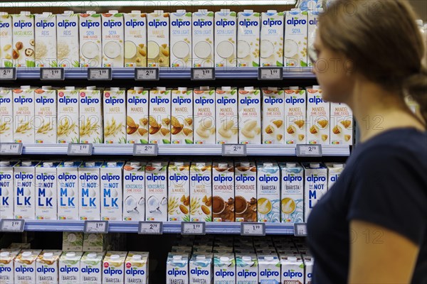 Young woman buys a product from alpro. in the supermarket, Radevormwald, Germany, Europe