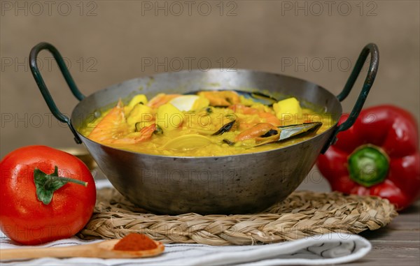 Typical spanish seafood paella in a metal casserole with all its ingredients