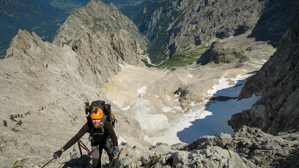 Tourist with equipment on the via ferrata trail in the alps. Zugspitze massif