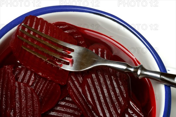 Sliced pickled beetroot with peel and fork