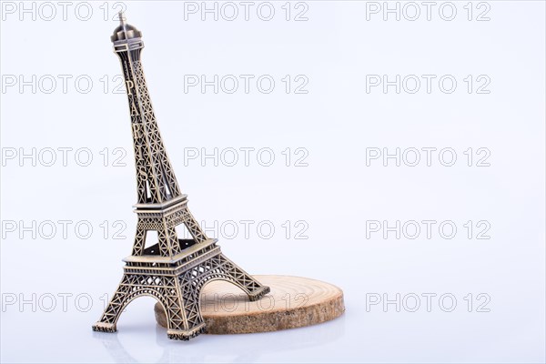 Little model Eiffel Tower on a wooden piece