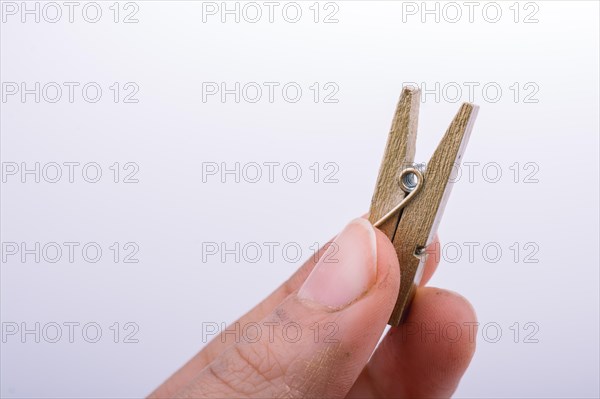 Hand holding a small wooden clothespin in hand