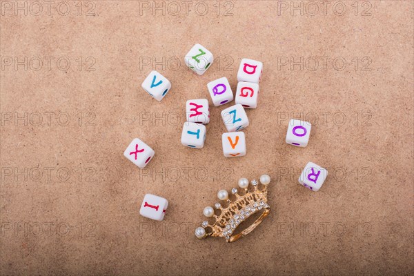 Golden color crown model in front of the letter cubes