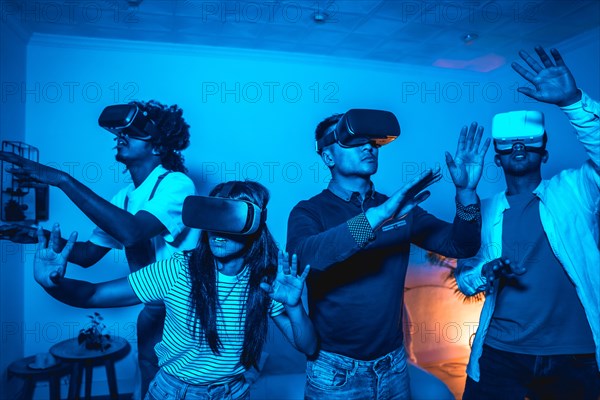 Group of young people in vr glasses in a virtual reality game in a blue light