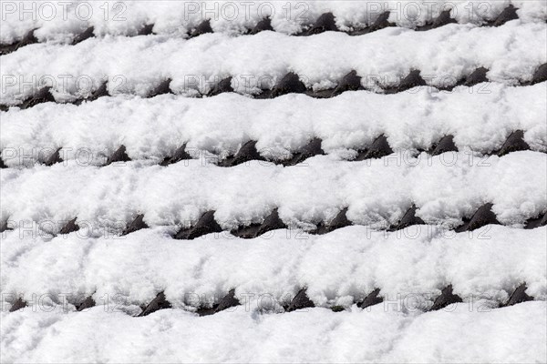Snowy roof tiles on a roof in winter