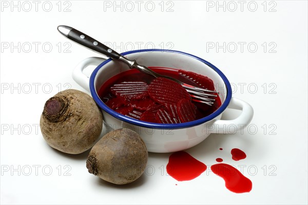 Sliced pickled beetroot with peel and fork