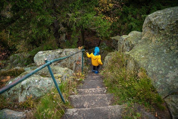 The child descends the stone steps on the hiking trail in the mountains. Polish mountains