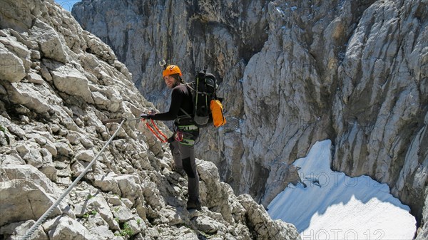 Tourist with equipment on the via ferrata trail in the alps. Zugspitze massif