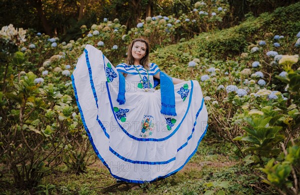 Girl in Nicaraguan national folk costume. Young Nicaraguan woman in traditional folk costume in a field of Milflores