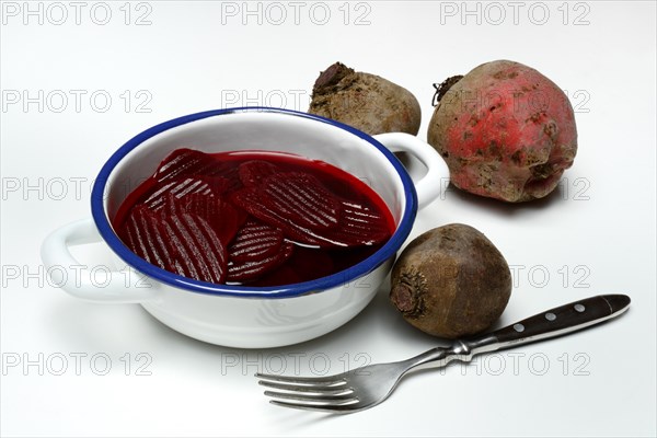 Sliced pickled beetroot with peel and fork