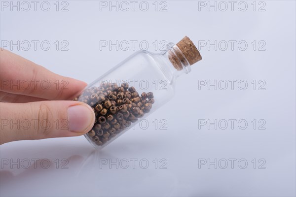 Little perfume glass bottle in hand on a white background