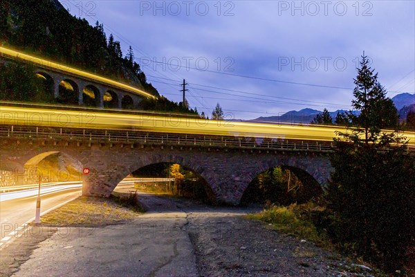 Two railway bridges with train at night