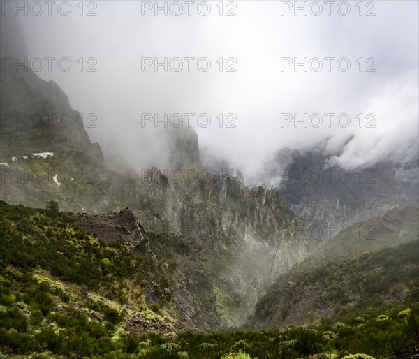 Steep cloudy mountain landscape with rock formations