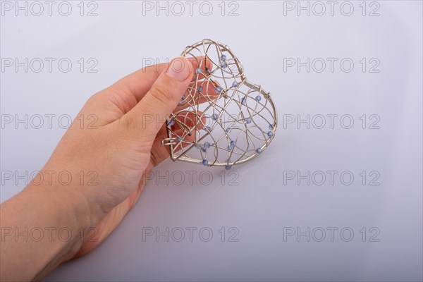 Heart shaped silver color metal wire cage in hand