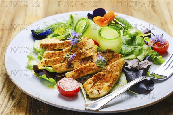 Roasted chicken breast with summer salad served on a plate