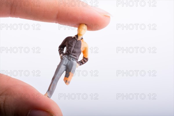 Little man figure with a crippled leg in hand on a white background