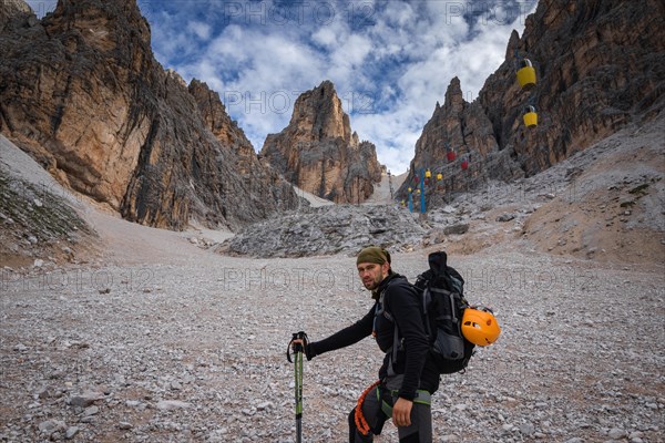 Tourist in inventory on the gutter trail with gondola lift to Forcella Staunies