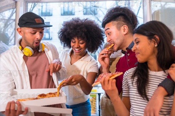 Portrait of a group of friends eating pizza on the terrace at home