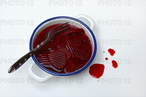 Sliced pickled beetroot with peel and fork