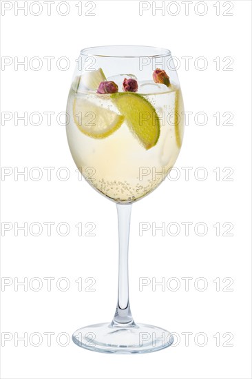 Cold white sangria with dry rosebuds in wine glass isolated on white background