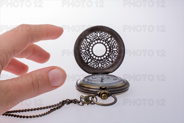 Retro style pocket watch in hand on white background