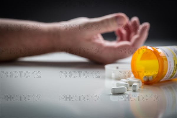 Man passed out on floor behind scattered drugs and medicine bottle