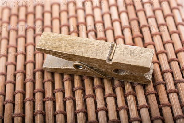 Small wooden clothespin placed on straw background
