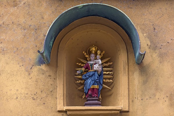 Sculpture of Mary with the Child Jesus in a niche on a residential house