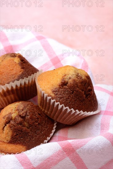 Chocolate muffins in kitchen towel