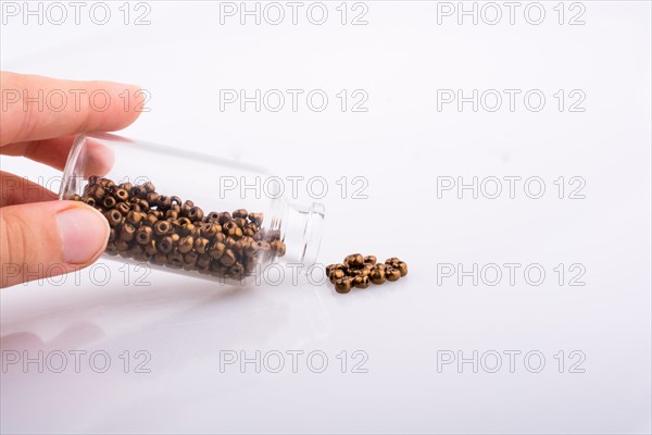 Little perfume glass bottle in hand on a white background