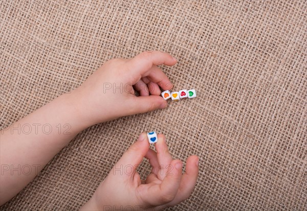 Little cubes with heart shape in hand on canvas